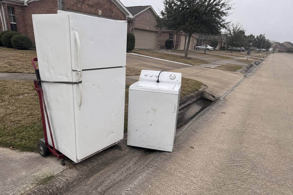 An old refrigerator and washer moved to the curb on an appliance dolly